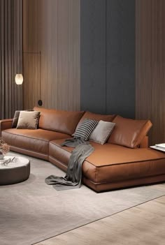 a large brown leather couch sitting in a living room next to a table and lamp