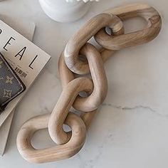 a wallet and chain sitting on top of a table next to a magazine with the word deal written on it