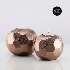 two wooden candles sitting next to each other on top of a white table with a black dot