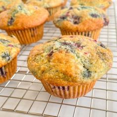 muffins cooling on a wire rack with blueberries and cranberries in them