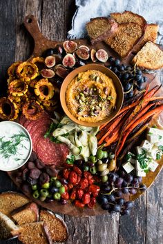 a platter filled with meats, vegetables and bread