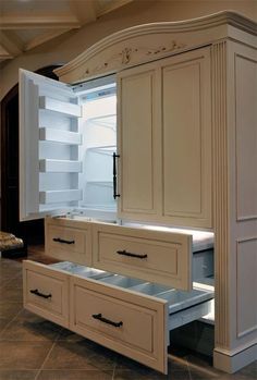 an empty kitchen with white cabinets and drawers