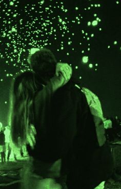 two people are kissing in front of fireworks