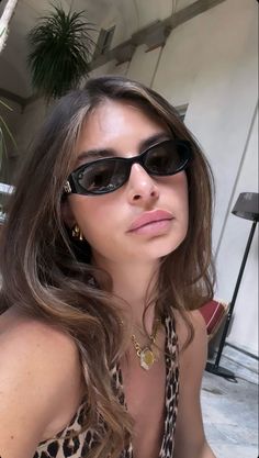 a woman wearing sunglasses sitting on the ground