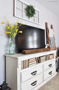 a flat screen tv sitting on top of a white dresser