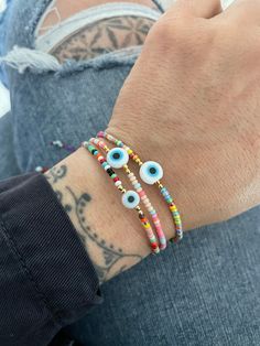 Unique simple yet powerful colorful beaded bracelets with a flat evil eye bead in the middle. Fun and colorful bracelets that will keep you safe and stylish at the same time. Perfect for layering if you like to wear many accessories. They are size adjustable, so this are the perfect gift for your love ones. They are available in 3 different colors for you to choose from. Red, Pastel and Purpel. (you can define them by the string color) A most have addition to your everyday bracelets. ⚡️GET 20% O Festival Evil Eye Bracelet With Colorful Round Beads, Multicolor Tiny Beads Evil Eye Bracelet, Multicolor Evil Eye Beaded Bracelets For Friendship, Adjustable Multicolor Evil Eye Beads, Bohemian Evil Eye Bracelet With Round Letter Beads, Bohemian Evil Eye Bracelet With Letter Beads, Bohemian Multicolor Evil Eye Bracelet With Tiny Beads, Multicolor Bohemian Evil Eye Bracelet With Tiny Beads, Spiritual Multicolor Evil Eye Bracelets