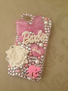 a cell phone case with pearls, beads and pink flowers on it's side