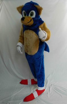 a person dressed in a blue and brown animal suit with red feet standing on a white background