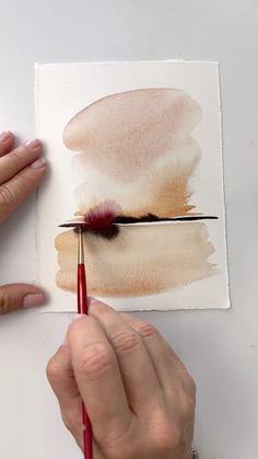 a person is painting with watercolors on paper