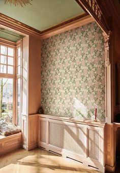 an empty room with two windows and a wall papered in floral designs on the walls