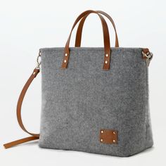 This felt bag with leather short handles and crossbody strap was created in my small studio. It was made out of very durable technical felt, 4mm thick and thick natural cowhide leather. It is a very minimalist larger size bag. Great gift idea for her. This handbag on first photos is made out of light gray felt and cognac leather. Other colors available. Please check the photos and choose your favourite color of the felt and leather. Measurements: width 31 cm/ 12.2 inch height 28 cm/ 11 inch dept Everyday Felt Tote Bag, Rectangular Felt Shoulder Bag For Daily Use, Daily Use Rectangular Felt Shoulder Bag, Leather Short, Small Studio, Felt Bag, Work Bag, Leather Shorts, Travel Tote