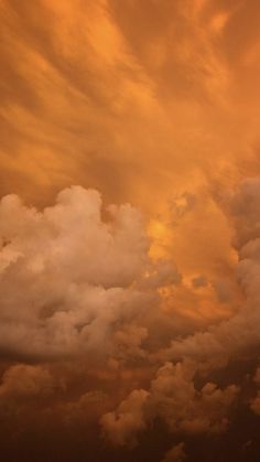 an airplane is flying in the cloudy sky