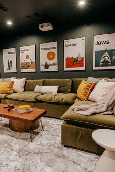 a living room with couches and pictures on the wall above them, along with a coffee table