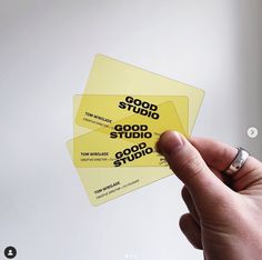 someone holding up some yellow business cards with the words good studio written on one side