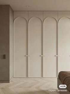 a bedroom with white closets and wooden flooring in the room, along with a bed