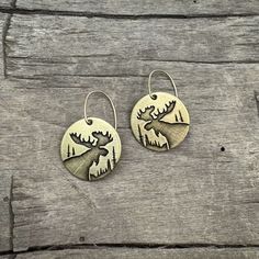 Experience the beauty of the wilderness with our Creek Moose Earrings. Adorned with the majestic moose, these earrings capture the essence of spotting a moose in tall grass by a river. Let the large antlers of the moose inspire you to embrace your strength and grace. The two earrings are reflective as they face each other. For the silver finish, the ear wires are sterling silver, and for the antique brass finish, we use 14k gold filled. This style is offered in two finishes: Matte Silver and Ant Two Earrings, Cuff Rings, The Wilderness, Antique Earrings, Leather Cuffs, Antlers, Brass Finish, Adjustable Rings, Men Necklace