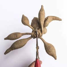 a person holding a pair of scissors cutting through a piece of fabric that has been made to look like a flower