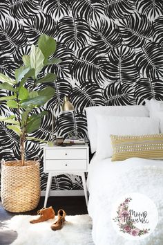 a bedroom with black and white wallpaper, a plant in a basket next to the bed