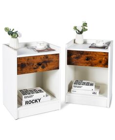 two small wooden nightstands with books and vases on each side, one is white