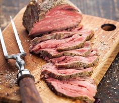 some meat is on a cutting board with a knife