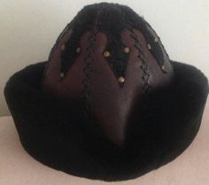 "Completely hand stitched Handmade This Leather hat is extremely thick and very warm.Made Genuine leather and Sheep Fur. Please be sure to measure the size of your head before buying. Measuring; Measuring for your head size is, You can use a tape measure (or a length of string that you will have to hold up to a tape measure) to determine the length. Place the string or tape around your head about 1/8\" above your ear, across the mid-forehead, completely circling your head. Hold the tape firmly, Traditional Handmade Costume Hats And Headpieces, Handmade Brimmed Costume Hats And Headpieces For Festival, Handmade Brimmed Costume Hats For Festival, Vintage Handmade Brimmed Costume Hat, Traditional Handmade Black Hat Bands, Handmade Artisan Hat Bands For Winter, Handmade Brimmed Festival Costume Hats And Headpieces, Handmade Short Brim Costume Hats For Festivals, Handmade Vintage Brimmed Costume Hats