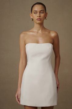 We recommend sizing up in this style. When the dress IS the party.The NEEKA is a strapless mini dress with a low sweetheart neckline and flared skirt. Three beautiful contrast bows are lined up at the centre back, adding visual texture and a touch of feminine charm. The back itself is low with a deep V-shaped neckline. Airy tulle underlayers add playful volume while the tucked waist accentuates a slender, curvy silhouette. Flatteringly feminine, NEEKA is the perfect blend of childish whimsy and Strapless Bridesmaid Mini Dress With Boned Bodice, Strapless Dress With Boned Bodice For Gala, Elegant Bandeau Dress With Corset Back, Elegant Bandeau Mini Dress With Fitted Bodice, Gala Strapless Dress With Boned Bodice And Straight Neckline, Formal Strapless Mini Dress With Corset Back, Strapless Mini Dress For Wedding With Lined Bodice, Strapless Mini Dress With Fitted Bodice For Wedding, Strapless Mini Dress For Wedding