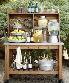 an outdoor bar with lemons, bottles and glasses