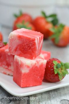 strawberry cheesecake fudges on a plate with strawberries