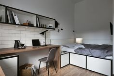 a bedroom with a bed, desk and shelves