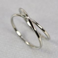 two thin silver rings on a white surface