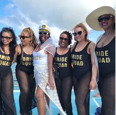 a group of women standing next to each other on top of a blue swimming pool