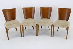 four wooden chairs with upholstered back cushions