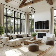 a living room filled with lots of furniture next to large windows and a flat screen tv mounted on the wall