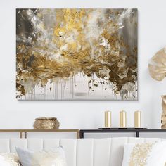 a living room with white couches and gold accents on the wall above it is an abstract painting