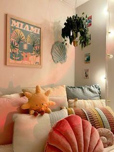 there is a stuffed animal on the pillow in this room with pink walls and pillows