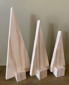 three pieces of wood sitting on top of a wooden table next to each other,