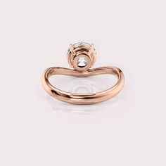 a rose gold engagement ring with a single diamond in the center and an open band