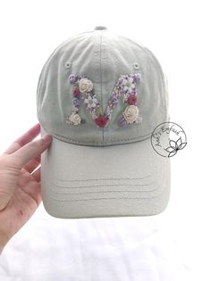 Hand Embroidered Letter Hat Baseball Cap Material: This khaki fabric cap is embroidered with cotton thread. You can adjust circumference of the hat. - Cap circumference : 54-58 cm - Cap depth: 12 cm - Cap brim length: 7 cm -Color: Green grey I love embroidery and I think this is a gift of thought for this life. If you like, own it or give this meaningful gift to relatives and friends. NOTE: The color can slightly be different due to monitor setting. Please make sure you do not mind this when pur Embroidered Hats Ideas, Custom Baseball Cap, Pretty Hats, Embroidery Caps, Denim Cap, Flower Hat, Floral Hat, Hat Baseball, Flower Hats