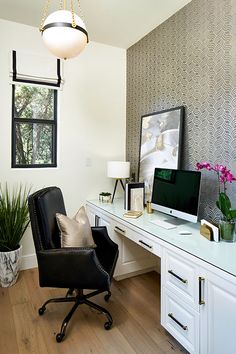 a desk with a chair and computer on it in a room that has wood floors