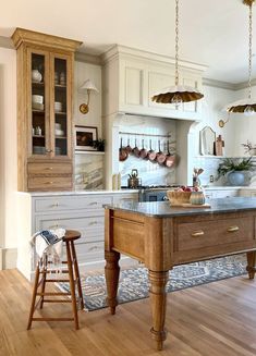 a large kitchen with an island in the middle and wooden stools at the end