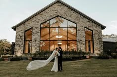 a bride and groom standing in front of a church