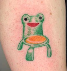 a frog with a frisbee on his leg that is painted green and orange