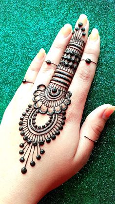 a woman's hand with henna tattoos on it