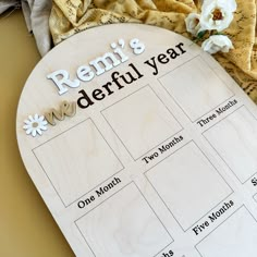 a wooden calendar with flowers on top of it next to some cloths and napkins