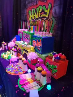 there are many colorful cakes and cupcakes on the table at this birthday party