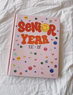 a pink book with the words senior year written in orange and red on it's cover