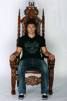 a man sitting in a chair made out of wood