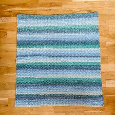 a blue and green rug sitting on top of a wooden floor