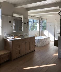 a large bathroom with two sinks and a bathtub in the middle of the room