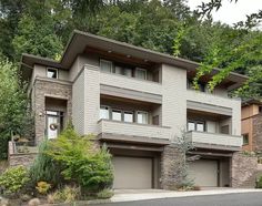 a large house in the woods with two garages